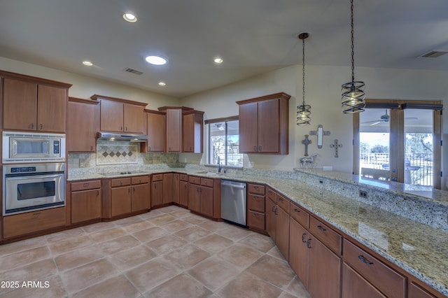 kitchen with hanging light fixtures, backsplash, stainless steel appliances, light stone countertops, and kitchen peninsula