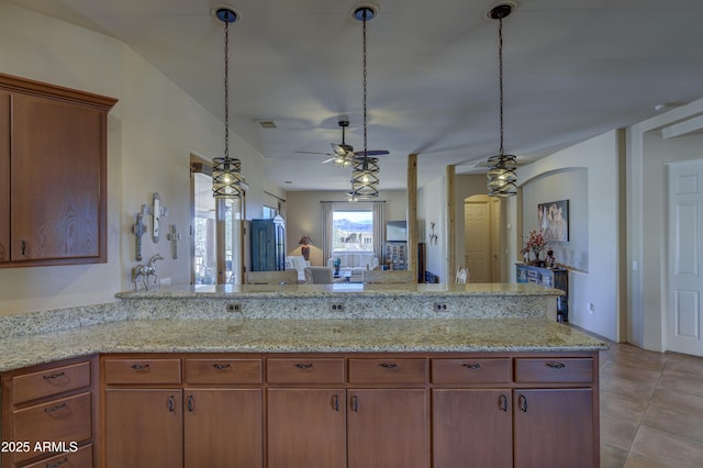 kitchen featuring pendant lighting, kitchen peninsula, and light tile patterned floors