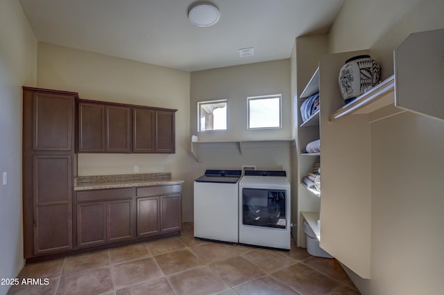 laundry area with cabinets, washing machine and dryer, and light tile patterned floors