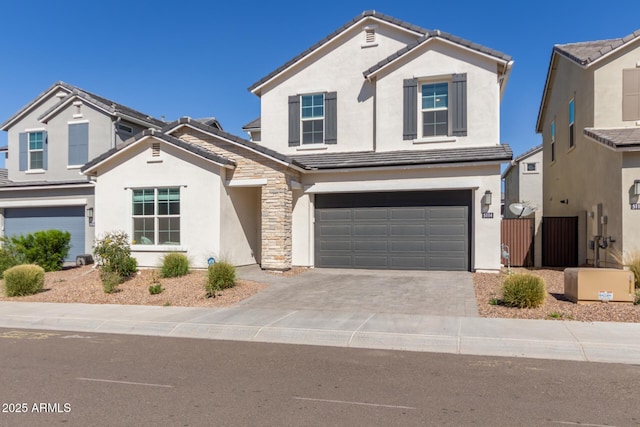 traditional-style house featuring driveway, an attached garage, and stucco siding