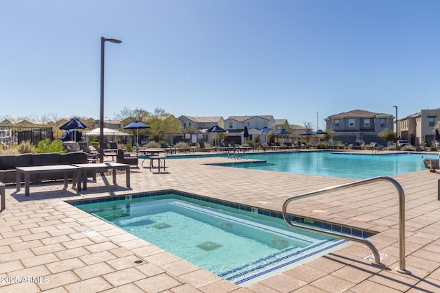 community pool featuring a patio area, a residential view, and fence