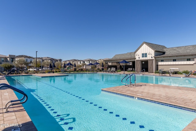 community pool with a patio area and a residential view