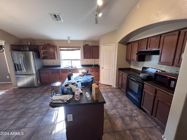 kitchen with a breakfast bar, sink, stainless steel fridge, a center island, and black range with electric cooktop