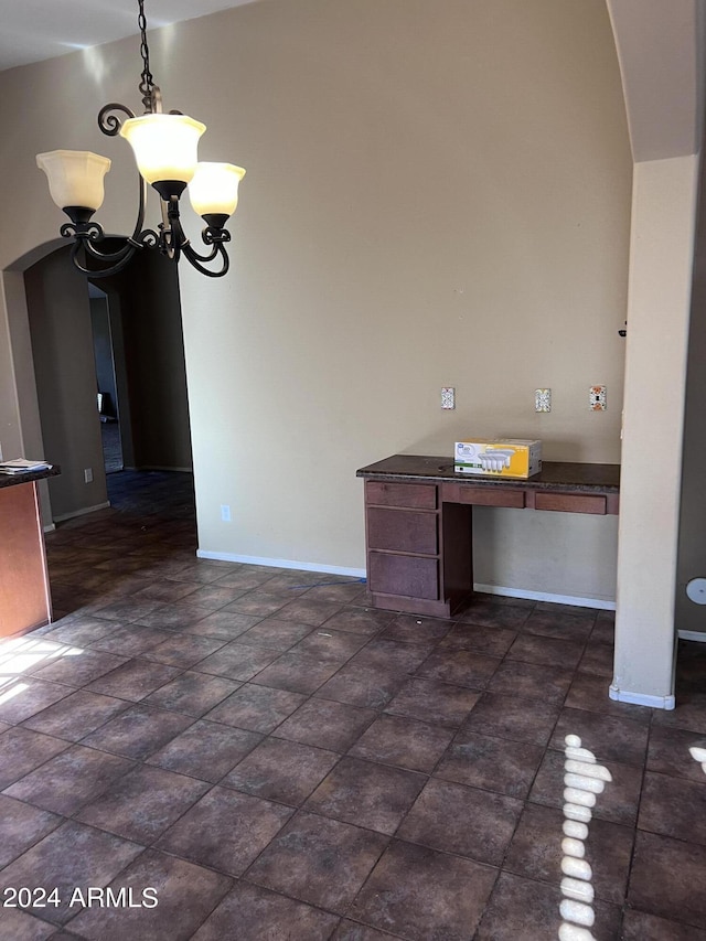 unfurnished dining area featuring a chandelier