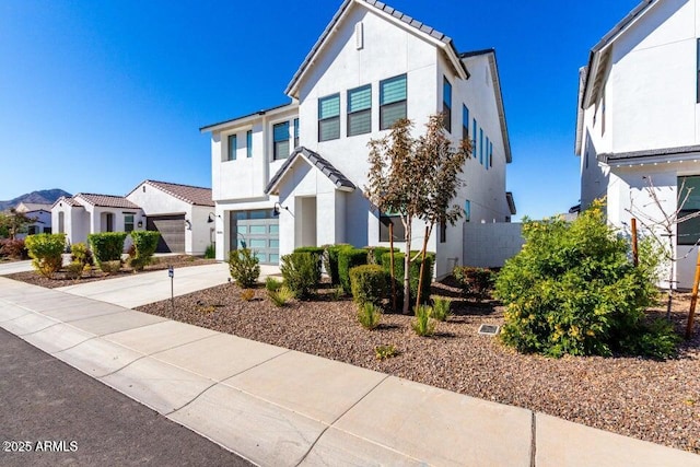 traditional home featuring stucco siding, a tiled roof, a garage, a residential view, and concrete driveway