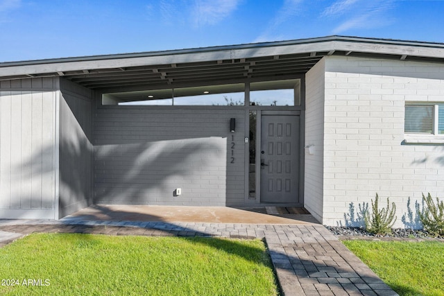 property entrance with a lawn