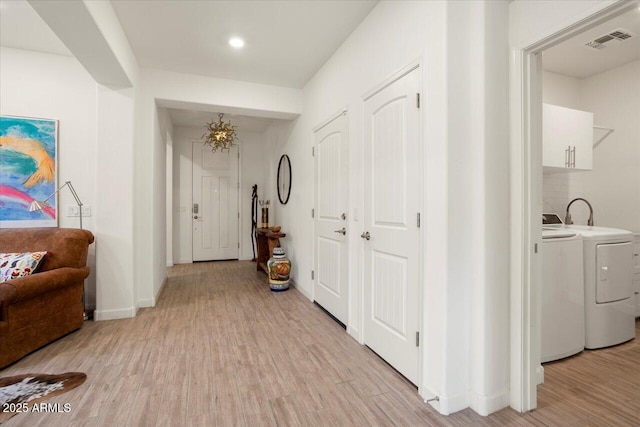 hall with washer and dryer and light wood-type flooring