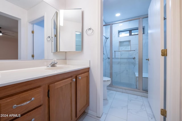 bathroom with vanity, ceiling fan, toilet, and walk in shower