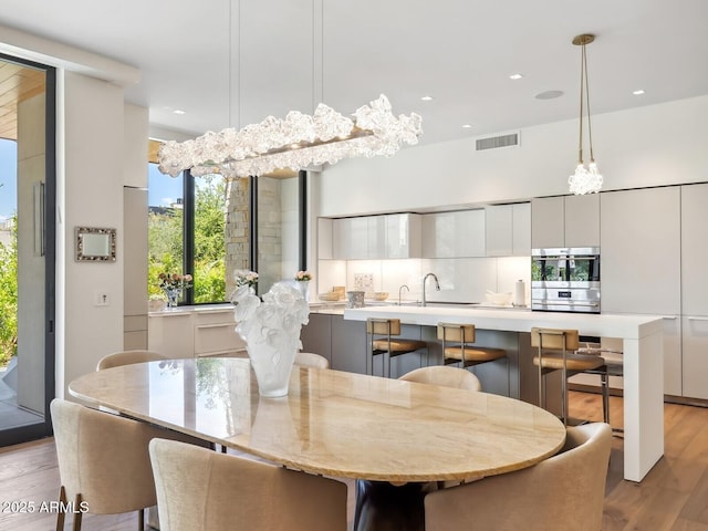 dining room with light wood-style flooring and recessed lighting