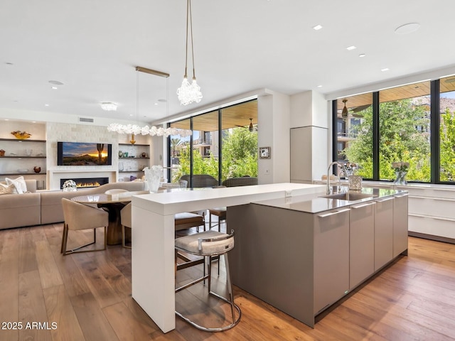 kitchen with a sink, modern cabinets, healthy amount of natural light, an island with sink, and recessed lighting