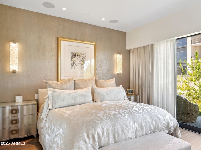 bedroom featuring wood finished floors and access to exterior