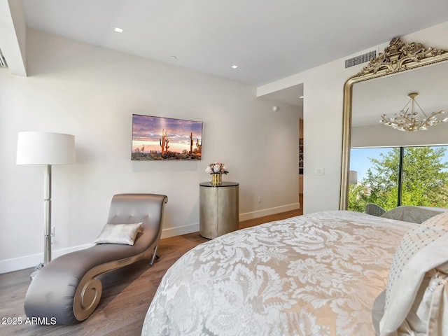 bedroom featuring a chandelier, wood finished floors, baseboards, and recessed lighting
