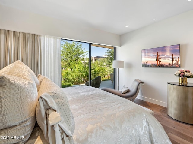 bedroom featuring wood finished floors, baseboards, and recessed lighting