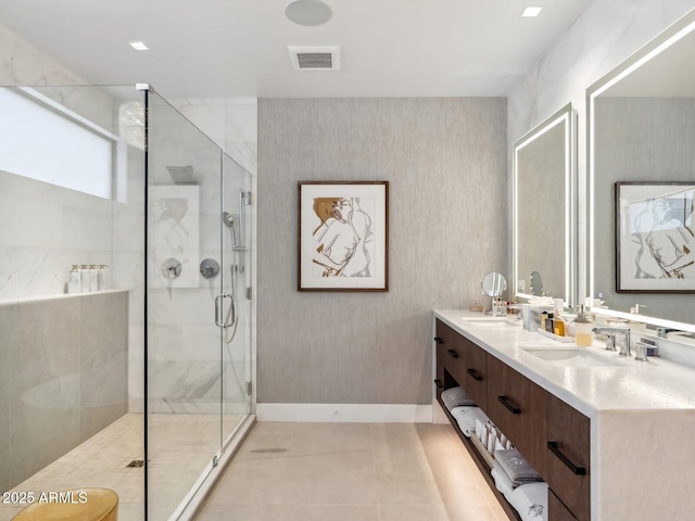 bathroom with baseboards, a shower stall, tile patterned flooring, and double vanity