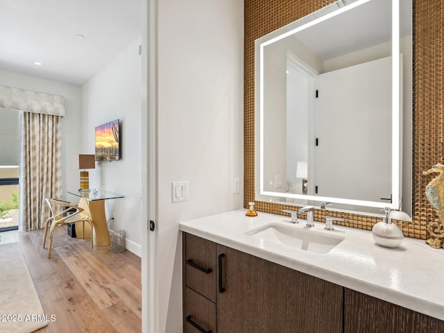bathroom with wood finished floors, vanity, and baseboards