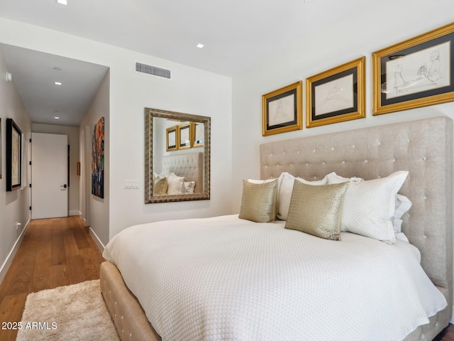 bedroom with wood finished floors, baseboards, and recessed lighting