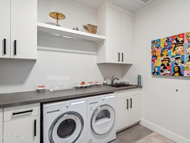 laundry room featuring washer and clothes dryer, cabinet space, tile patterned floors, and baseboards