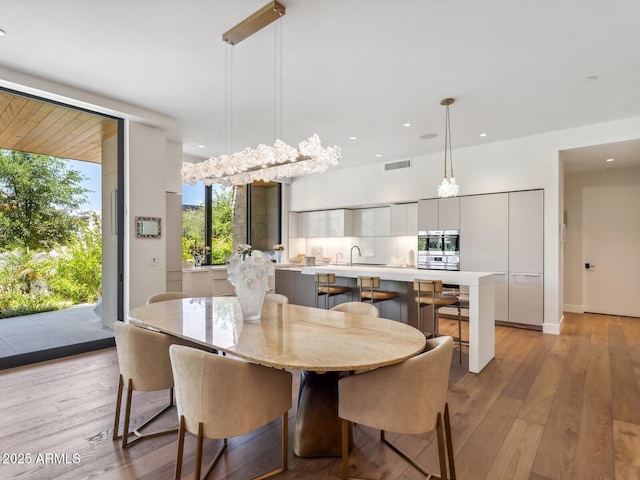 dining space featuring light wood-type flooring and recessed lighting