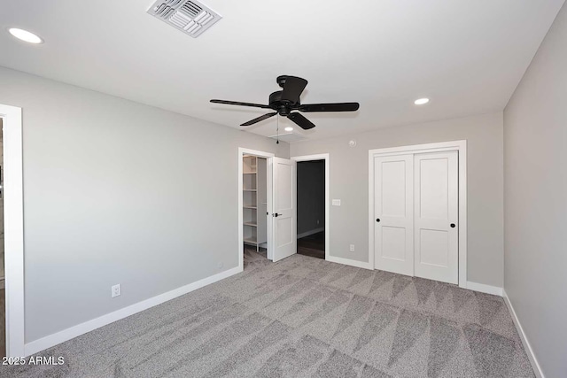 unfurnished bedroom with light colored carpet, ceiling fan, and a closet