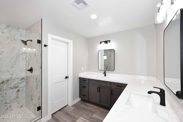 bathroom featuring hardwood / wood-style flooring, vanity, and a shower with door