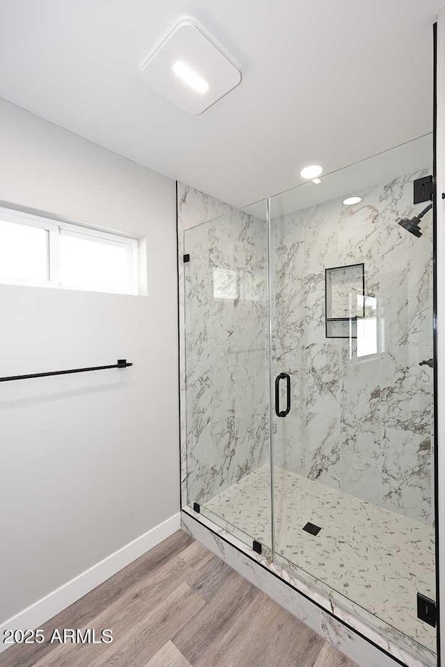 bathroom featuring wood-type flooring and an enclosed shower