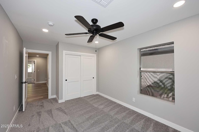 unfurnished bedroom with light colored carpet, a closet, and ceiling fan