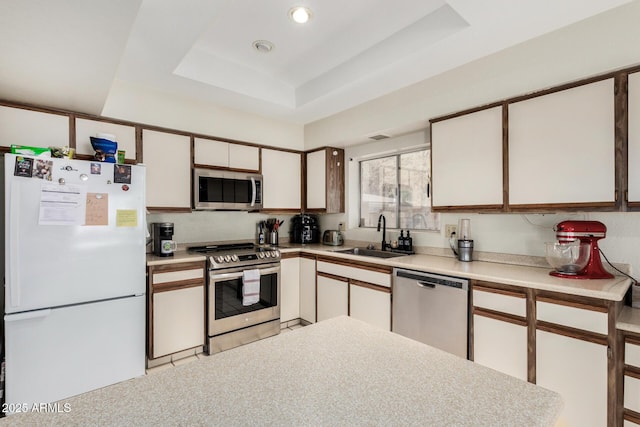 1012 E Wagon Wheel Dr, Phoenix, AZ 85020 - kitchen featuring stainless steel appliances, a tray ceiling, light countertops, and a sink