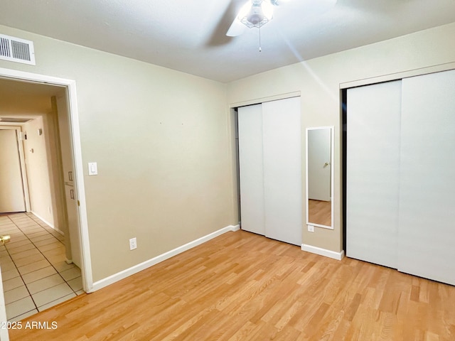 924 S Hacienda Dr Unit C, Tempe, AZ 85281 - unfurnished bedroom featuring multiple closets, light wood finished floors, baseboards, and ceiling fan