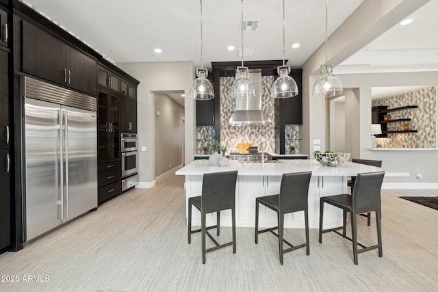 kitchen with tasteful backsplash, visible vents, a kitchen breakfast bar, stainless steel appliances, and light countertops