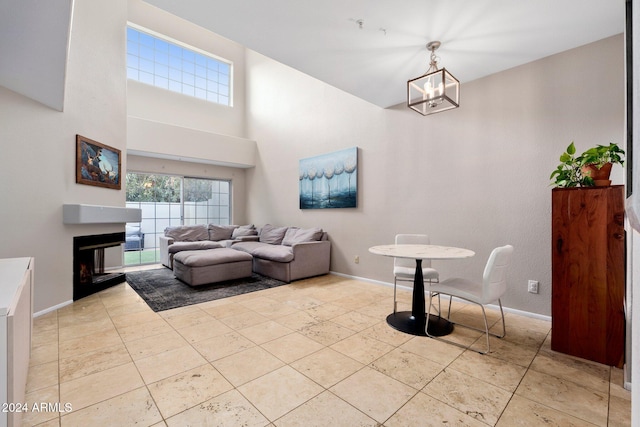 tiled living room with a fireplace and an inviting chandelier