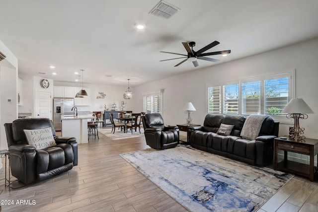 living room featuring light hardwood / wood-style floors and ceiling fan