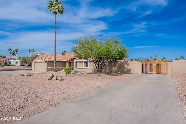 17207 E El Pueblo Blvd, Fountain Hills, AZ 85268 - view of front facade with concrete driveway, a gate, a fenced front yard, stucco siding, and a garage
