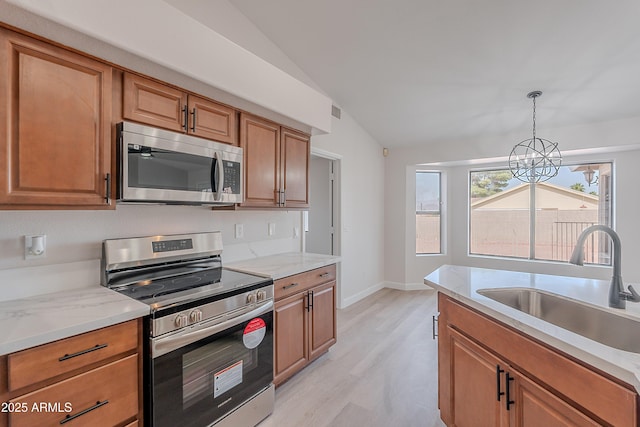 17207 E El Pueblo Blvd, Fountain Hills, AZ 85268 - kitchen featuring appliances with stainless steel finishes, vaulted ceiling, a sink, light wood-type flooring, and brown cabinets