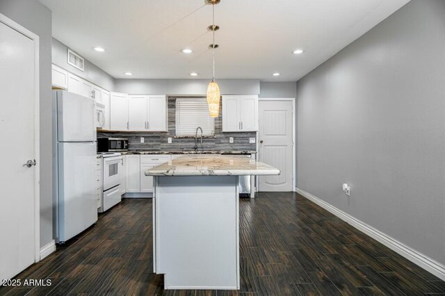 kitchen featuring a kitchen island, white cabinets, pendant lighting, white appliances, and backsplash