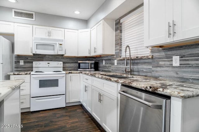 kitchen featuring light stone countertops, white cabinetry, appliances with stainless steel finishes, and sink