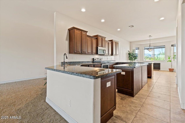 1623 E Hidalgo St, Apache Junction, AZ 85119 - kitchen featuring appliances with stainless steel finishes, a peninsula, a kitchen island, dark stone counters, and recessed lighting