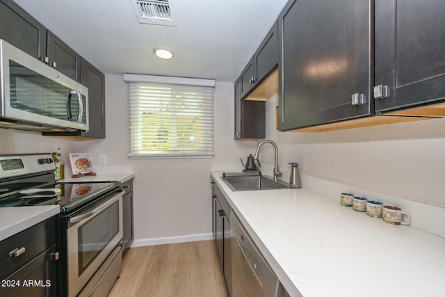 kitchen featuring light hardwood / wood-style floors, sink, and appliances with stainless steel finishes