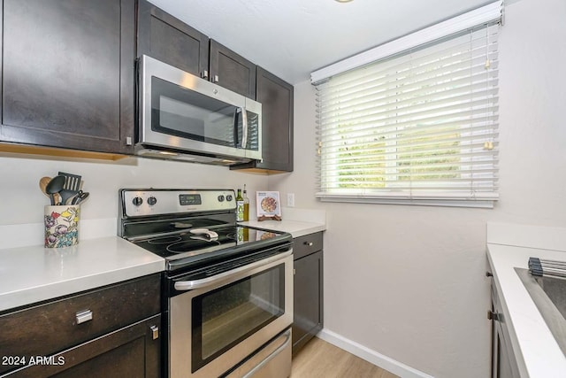 kitchen featuring stainless steel appliances, light hardwood / wood-style flooring, and dark brown cabinetry