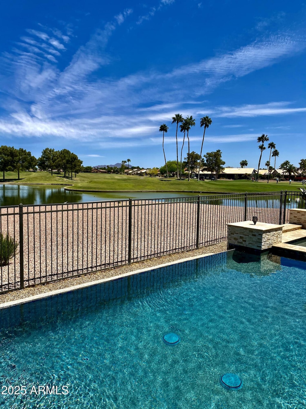 view of swimming pool featuring a water view and a fenced backyard