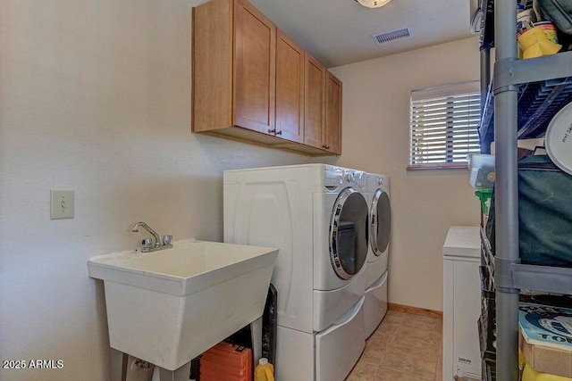 washroom with cabinets, sink, light tile patterned floors, and washing machine and clothes dryer