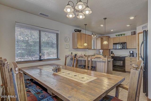 tiled dining area with an inviting chandelier and a textured ceiling