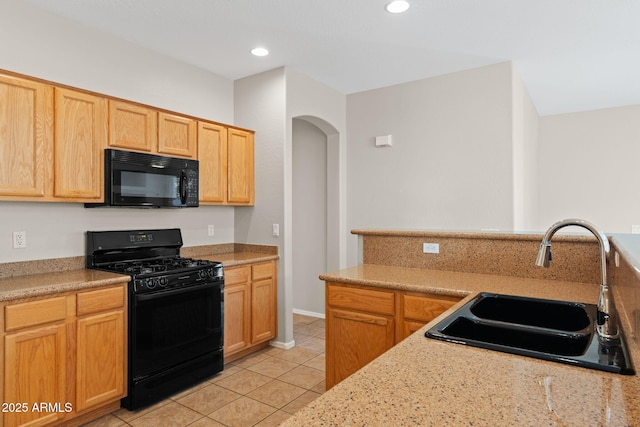 kitchen featuring black appliances, light stone countertops, light tile patterned flooring, sink, and light brown cabinets