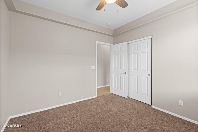 unfurnished bedroom featuring ceiling fan, a closet, and carpet floors