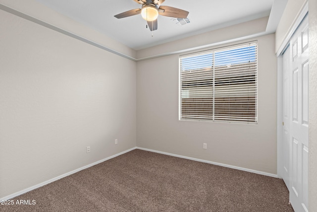 spare room featuring ceiling fan and carpet