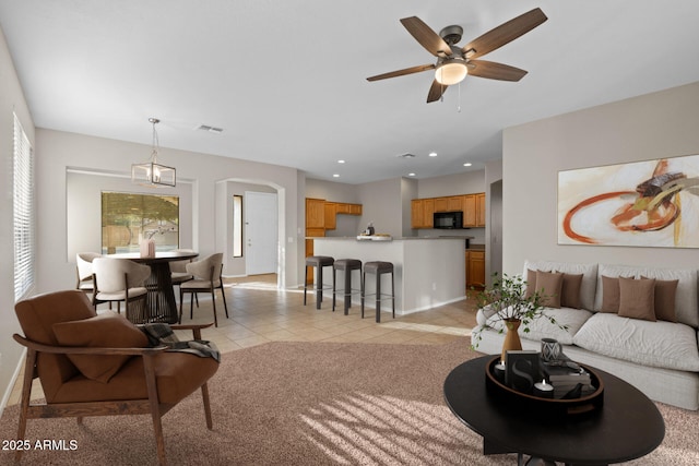 living room featuring light tile patterned floors and ceiling fan