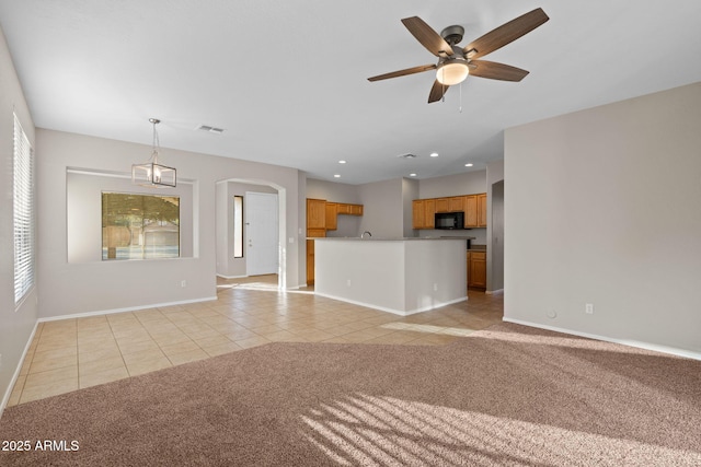 unfurnished living room with ceiling fan, plenty of natural light, and light tile patterned flooring