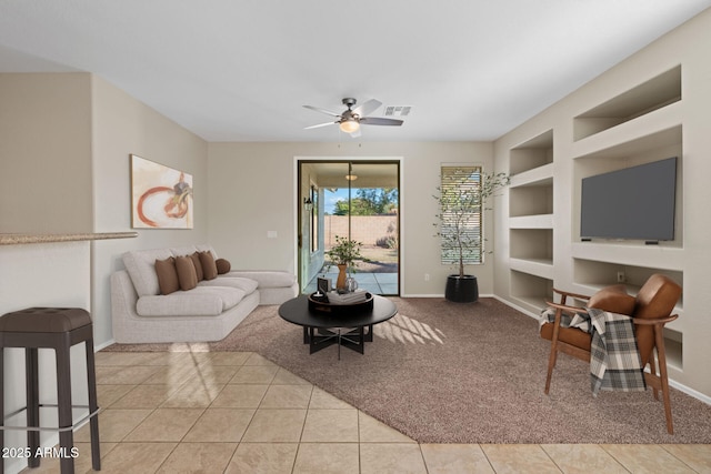 tiled living room featuring built in shelves and ceiling fan