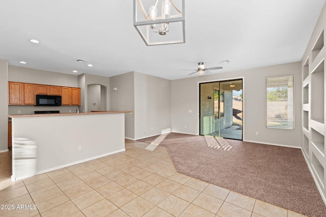 interior space with light tile patterned flooring and ceiling fan