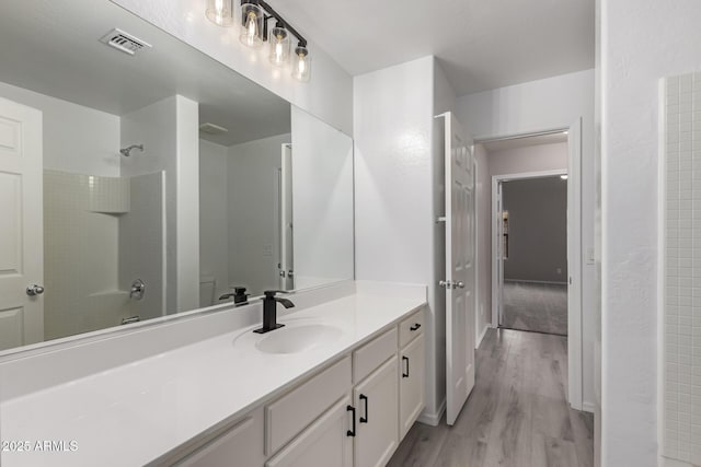 bathroom with hardwood / wood-style flooring, bathtub / shower combination, and vanity