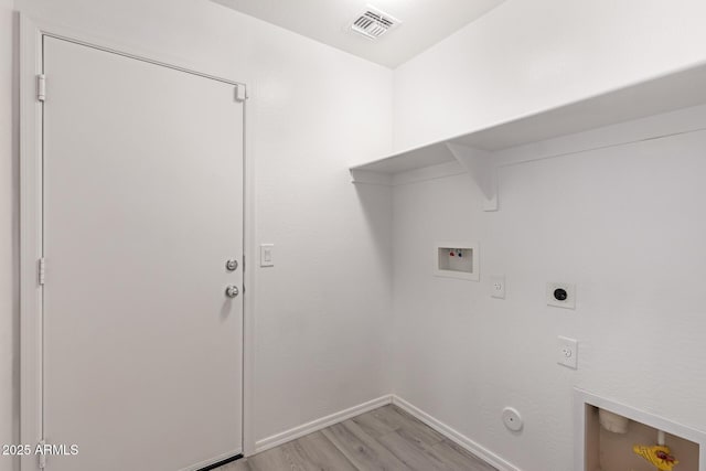 clothes washing area featuring hookup for a washing machine, light hardwood / wood-style flooring, electric dryer hookup, and hookup for a gas dryer